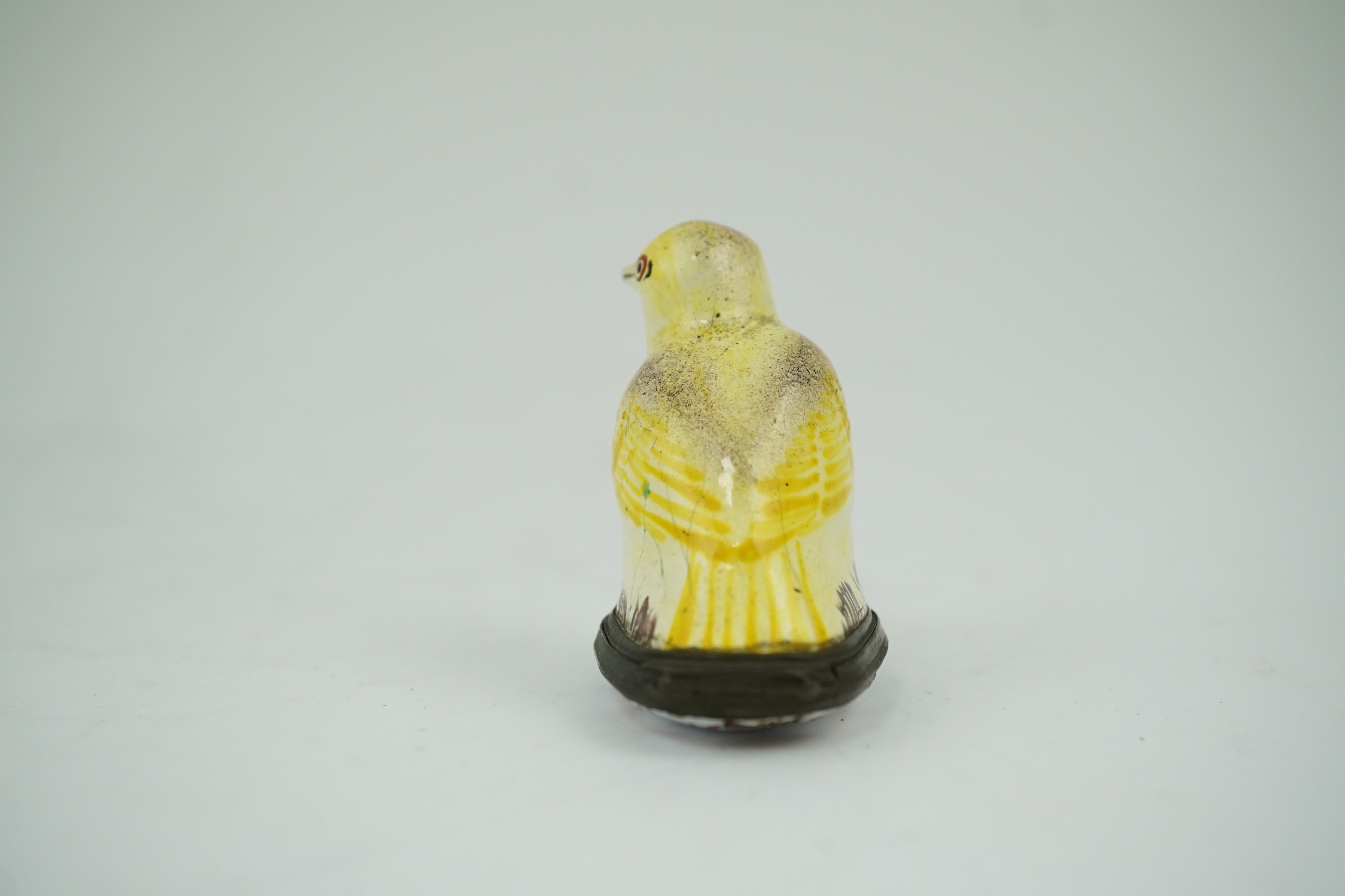 An 18th century South Staffordshire (Bilston) enamel box modelled as a canary with floral decorated lid, 4.5cm high. Condition - fair/poor